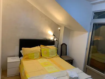 a bedroom with a bed with yellow sheets and a window at Apartmani MilaMi #3 in Kalugjerica
