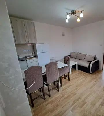 a living room with a table and chairs and a couch at Apartmani MilaMi #3 in Kalugjerica