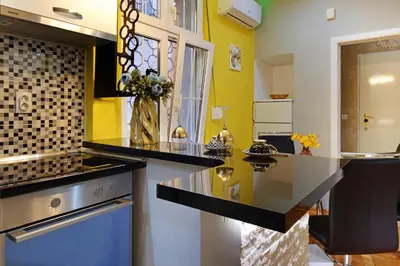 a kitchen with yellow walls and a counter top at APARTMAN KRUNA in Belgrade