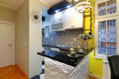 a kitchen with a black counter top at APARTMAN KRUNA in Belgrade