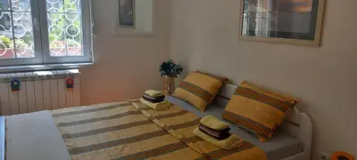a bedroom with a bed with pillows and a window at APARTMAN KRUNA in Belgrade