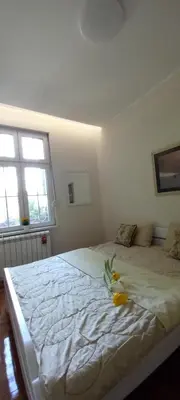 a bedroom with a bed with a flower on it at APARTMAN KRUNA in Belgrade
