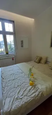 a bedroom with a bed with a flower on it at APARTMAN KRUNA in Belgrade