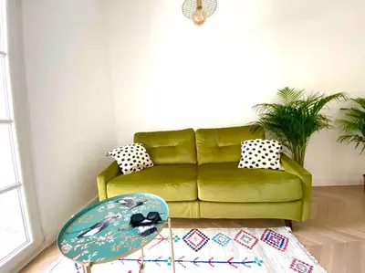 a living room with a green couch and a table at Soba 23 in Belgrade
