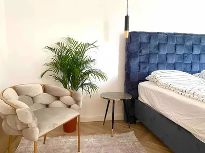 a bedroom with a bed and a chair and a plant at Soba 23 in Belgrade