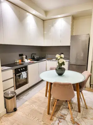 a kitchen with a table with a vase of flowers on it at Belgrade Waterfront - Beograd na vodi Lux Apartman in Belgrade