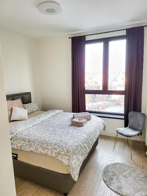 a bedroom with a bed and a chair and a window at Belgrade Waterfront - Beograd na vodi Lux Apartman in Belgrade