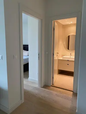 a white bathroom with a sink and a mirror at Belgrade Waterfront - Beograd na vodi Lux Apartman in Belgrade