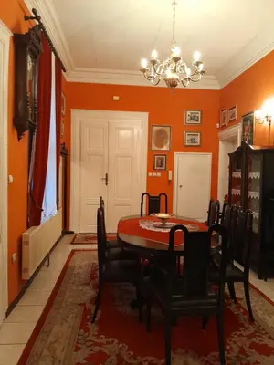 a dining room with orange walls and a table and chairs at VILA SREM in Ruma