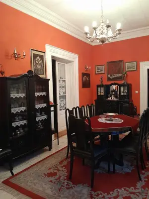 a dining room with red walls and a table and chairs at VILA SREM in Ruma