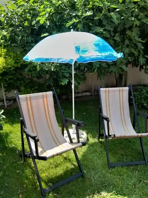 two chairs and an umbrella in the grass at VILA SREM in Ruma