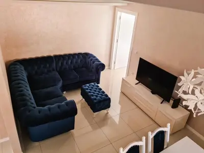a living room with a couch and a television at Apartman Cookie Kolačić blizu aerodroma Nikola Tesla in Dobanovci