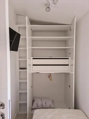 a room with a bed and a tv and shelves at Apartman Cookie Kolačić blizu aerodroma Nikola Tesla in Dobanovci