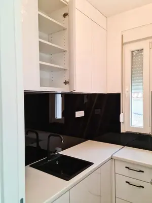 a kitchen with white cabinets and a sink at Apartman Cookie Kolačić blizu aerodroma Nikola Tesla in Dobanovci