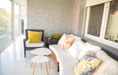 a living room with a white couch and a table at Apartman Cookie Kolačić blizu aerodroma Nikola Tesla in Dobanovci