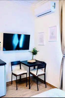 a black table with two chairs and a tv on a wall at Pop luxury apartments in Belgrade