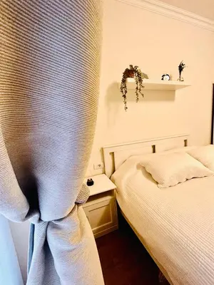 a bedroom with a bed and a window with a curtain at Pop luxury apartments in Belgrade