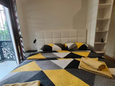 a bedroom with a large bed with a checkered blanket at City Center Belgrade Dorćol Square in Belgrade