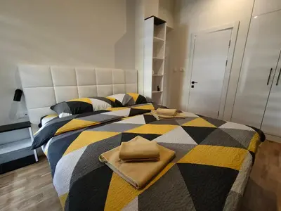 a bedroom with a large bed with a checkered blanket at City Center Belgrade Dorćol Square in Belgrade