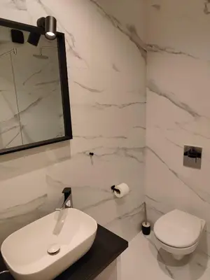 a white bathroom with a sink and a toilet at City Center Belgrade Dorćol Square in Belgrade