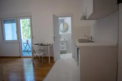 a white kitchen with a sink and a counter at Serene Bulbuder Suite in Belgrade