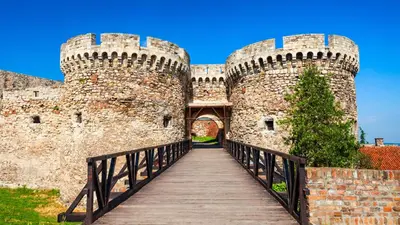 a medieval castle with a wooden bridge leading into it at Serene Bulbuder Suite in Belgrade