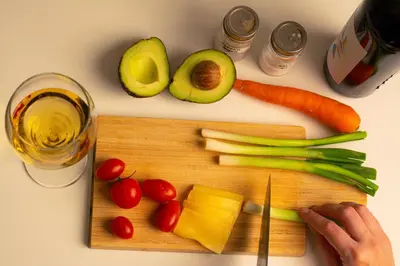 a cutting board with vegetables and a glass of wine at Serene Bulbuder Suite in Belgrade