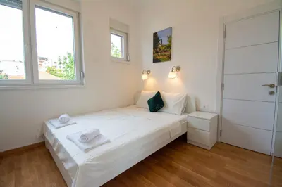 a bedroom with a white bed and a window at Serene Bulbuder Suite in Belgrade