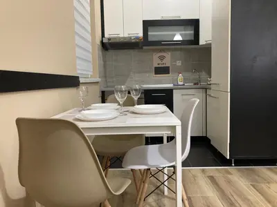 a kitchen with a table and chairs with wine glasses at Apartman Jany in Kijevo