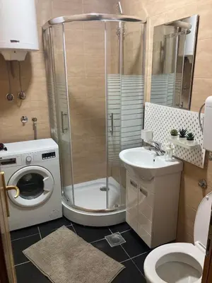 a bathroom with a shower and a toilet and a sink at Apartman Jany in Kijevo