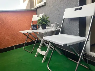 two white chairs and a table with a plant at Apartman Jany in Kijevo