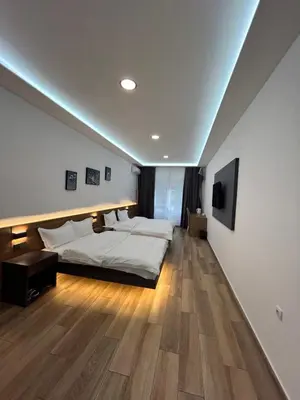 a bedroom with a bed and a television on the wall at H.T Hotel in Belgrade