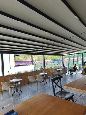 a restaurant with tables and chairs and a large window at H.T Hotel in Belgrade