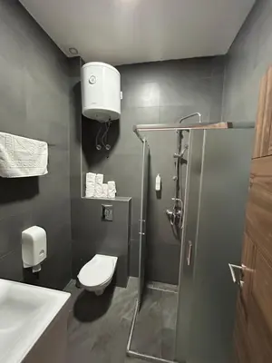 a bathroom with a shower and a toilet and a sink at H.T Hotel in Belgrade