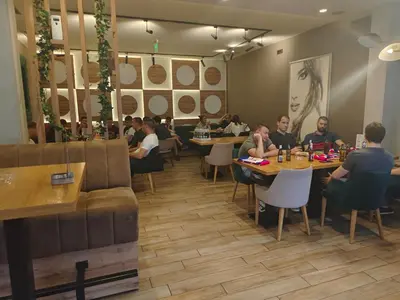 a group of people sitting at tables in a restaurant at H.T Hotel in Belgrade