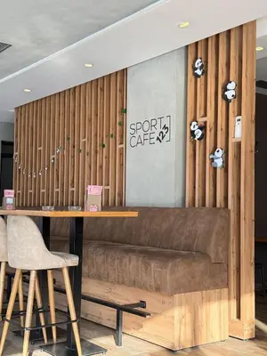 a bar with a brown couch in a room at H.T Hotel in Belgrade