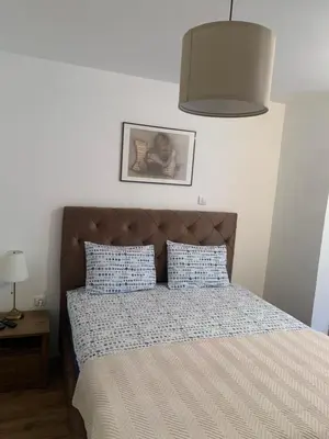a bedroom with a bed with blue and white sheets at Apartman ANN II in Pančevo