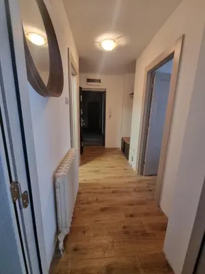 a hallway leading to a room with a hard wood floor at Apartman ANN II in Pančevo