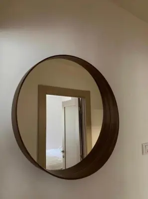 a mirror on a wall with a wooden frame at Apartman ANN II in Pančevo