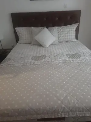 a bed with a white comforter and a pillow at Apartman ANN II in Pančevo