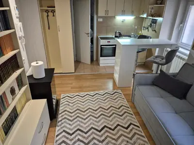 a living room with a couch and a kitchen at River Walk 2 in Sajmište