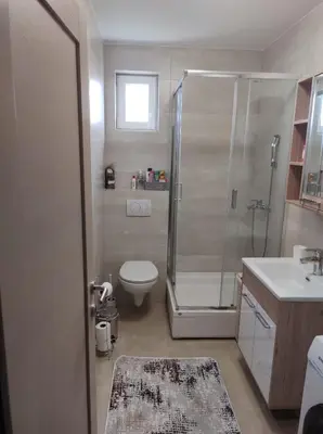 a bathroom with a shower and a toilet and a sink at Noa in Ledine