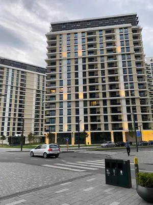 a large building with a car parked in front of it at Symphony707 - Belgrade waterfront in Belgrade