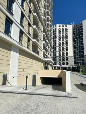 a bench in front of a building with tall buildings at Symphony707 - Belgrade waterfront in Belgrade