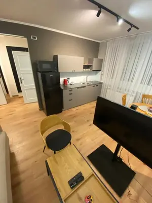 a living room with a television and a chair and a kitchen at Admiral Downtown 2 in Belgrade