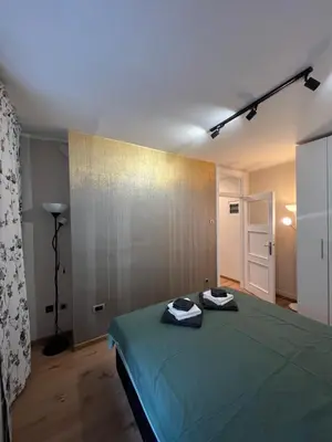 a bedroom with a green bed with two towels on it at Admiral Downtown 2 in Belgrade