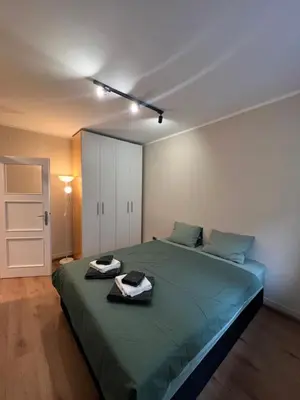 a bedroom with a large green bed with towels on it at Admiral Downtown 2 in Belgrade