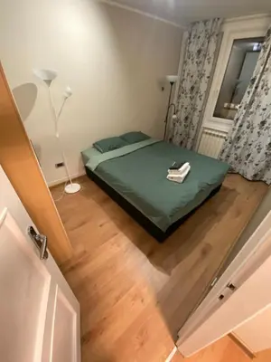 a small bedroom with a green bed and a window at Admiral Downtown 2 in Belgrade