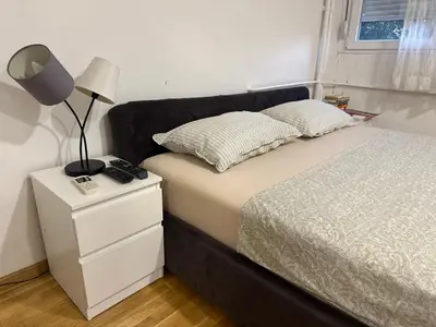 a bedroom with a bed and a lamp on a nightstand at Apartman Pupin in Belgrade