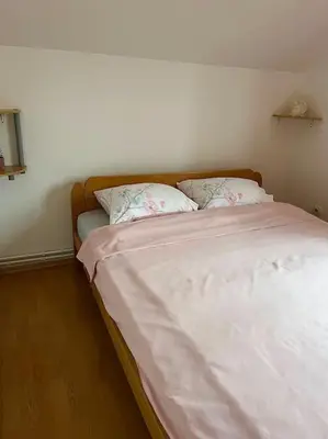 a bed with white sheets and pillows in a bedroom at Apartman Flora in Novi Grad